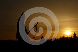 silhouette of native american shaman with pikestaff on background of sunset beutiful in mountains