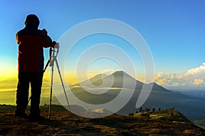 Silhouette nature photographer in action during sunrise