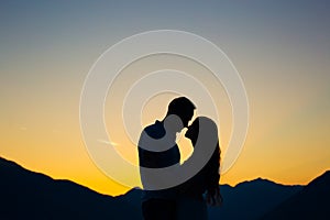 Silhouette of a newlywed couple on the background of the setting sun