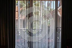 Silhouette noise and grain transparent curtain with sunlight in hotel bedroom