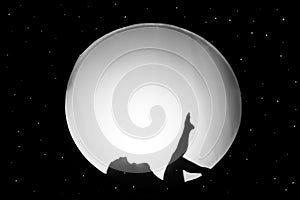 Silhouette of nude girl, against a white background in the form of a circle in black space