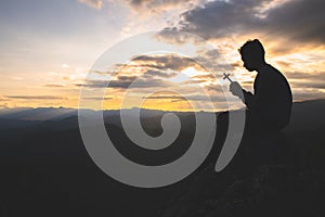 Silhouette off hands holding wooden cross  on sunrise background, Crucifix, Symbol of Faith