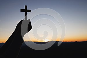 Silhouette off hands holding wooden cross  on sunrise background, Crucifix, Symbol of Faith