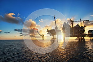 Silhouette,Offshore oil platform in sunset or sunrise time. Construction of production process in the sea. Power energy of the