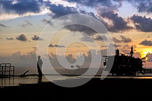 A silhouette of an offshore worker with oil production platforms at offshore oil field