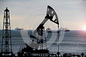 Silhouette of oil derricks on a sunset background. Oil and gas production concept. With place for your text