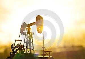 Silhouette of an oil drilling pump against a background