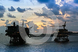 A silhouette of an oil production platforms at offshore oil field