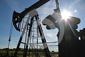 Silhouette of an oil pump jack in a field