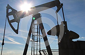 Silhouette of an oil pump jack in a field