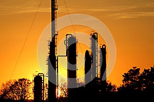 Silhouette of oil refinery against the sun