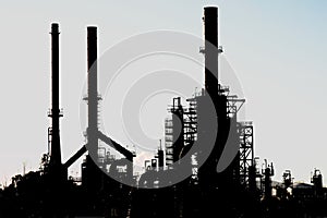 Silhouette of an oil refinery with chimneys