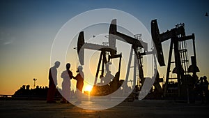 Silhouette of oil workers working in the evening