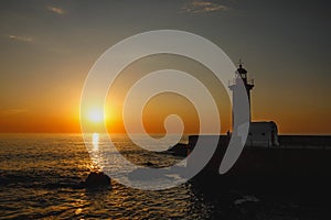 Silhouette of an old lighthouse during the sunset.