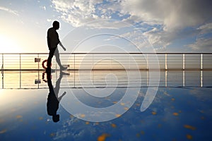 Silhouette of old man walking throught deck