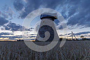 Silhouette of old mill without a wheel at Sunset