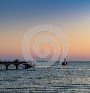 Silhouette of an old Viking ship saling off into the sunset on the Baltic Sea