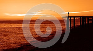 Silhouette of one alone Woman on Lakeside with majestic Sunset Cloudscape. Black sea. man wearing jacket of the sunset stands on