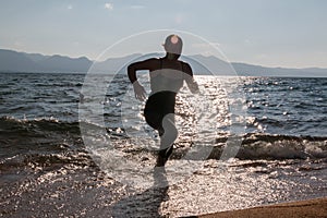 Silhouette of One Girl Running Through the Waves