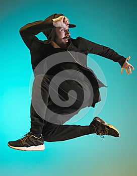 The silhouette of one hip hop male break dancer dancing on colorful background