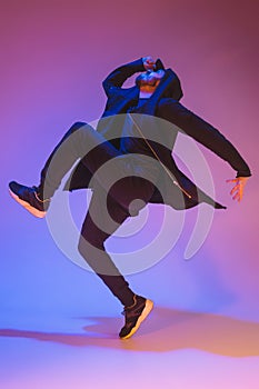 The silhouette of one hip hop male break dancer dancing on colorful background