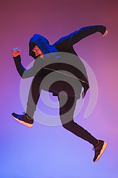 The silhouette of one hip hop male break dancer dancing on colorful background