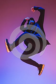 The silhouette of one hip hop male break dancer dancing on colorful background