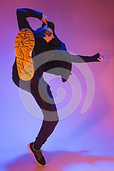 The silhouette of one hip hop male break dancer dancing on colorful background