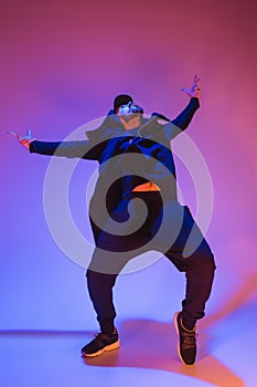 The silhouette of one hip hop male break dancer dancing on colorful background