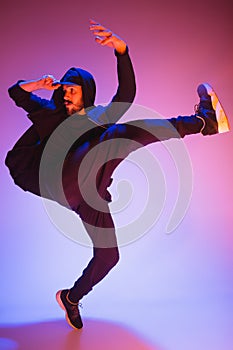 The silhouette of one hip hop male break dancer dancing on colorful background