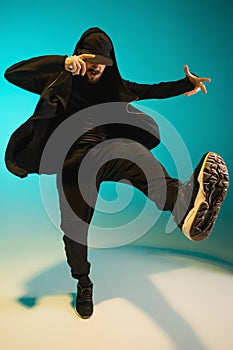 The silhouette of one hip hop male break dancer dancing on colorful background