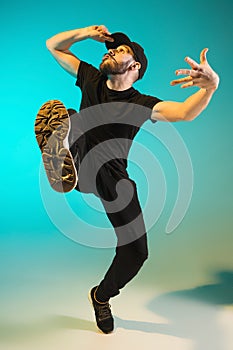 The silhouette of one hip hop male break dancer dancing on colorful background