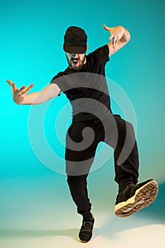 The silhouette of one hip hop male break dancer dancing on colorful background