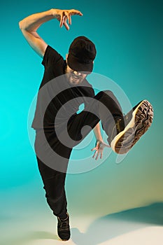 The silhouette of one hip hop male break dancer dancing on colorful background