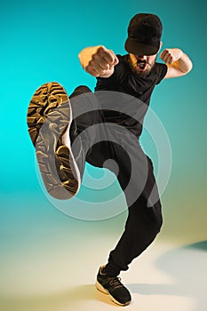 The silhouette of one hip hop male break dancer dancing on colorful background