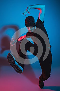 The silhouette of one hip hop male break dancer dancing on colorful background