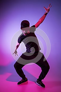 The silhouette of one hip hop male break dancer dancing on colorful background