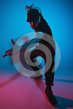 The silhouette of one hip hop male break dancer dancing on colorful background