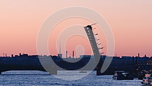 Silhouette of opened Trinity Bridge on the Neva early morning