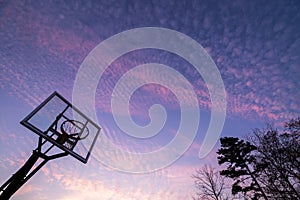 Silhouette of outdoor basketball goal with clear backboard and s