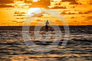 Silhouette of paddler with the sun rising behind