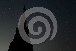 Silhouette of pagoda buddhism against night sky with copy space stars background.
