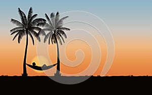 Silhouette palm tree with hammock on beach under sunset sky background