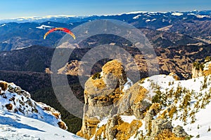 Silhouette of paraglide flying over the high mountains,Ceahlau,Romania