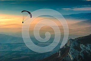 Silhouette of paraglider over the valley