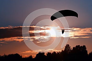 Silhouette paraglider pilot on sky