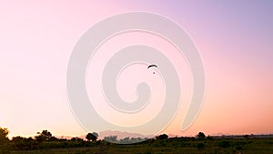 Silhouette of paramotor flying through over head