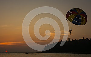 Silhouette of Parasailing at Kata beach with sunset background, extreme sports, Phuket, Thailand