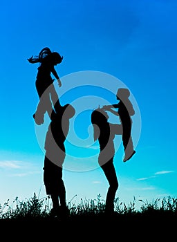 Silhouette of parents and children having fun spending time
