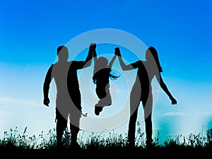 Silhouette of parents and kid having fun spending time